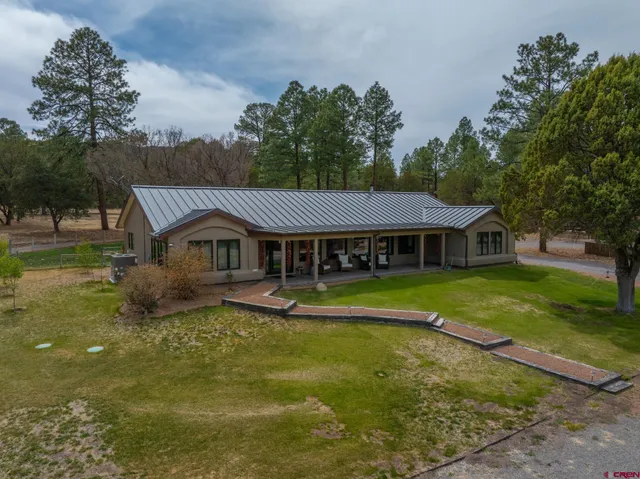 a aerial view of a house with swimming pool next to a yard
