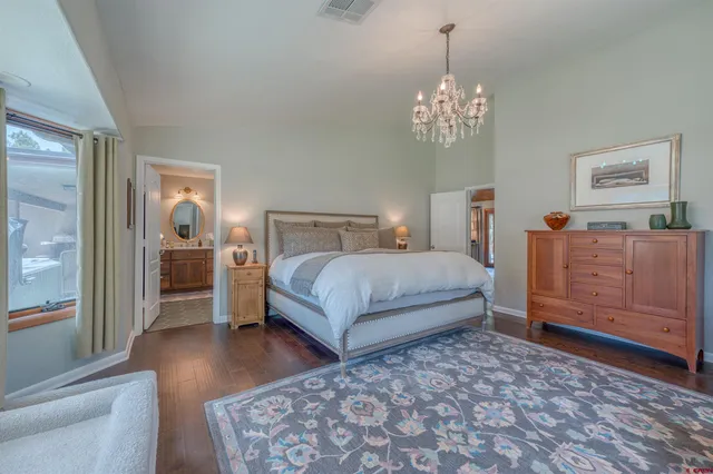 a bedroom with a bed chandelier and window