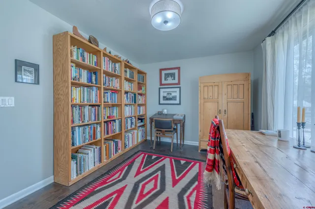a living room with lots of books and a window