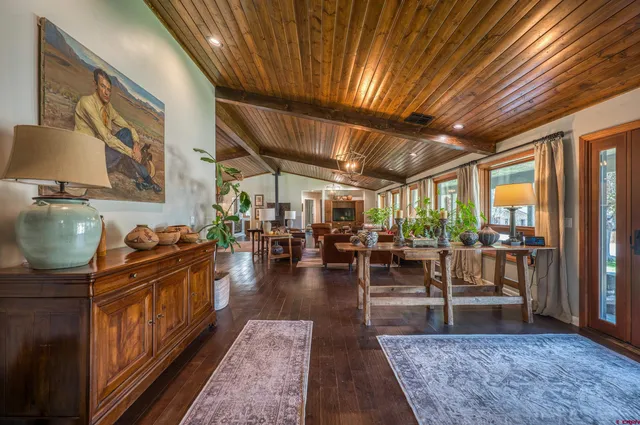a living room with lots of wooden furniture and a rug
