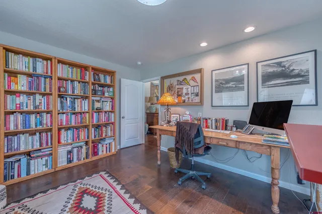 a view of a workspace with furniture and a bookshelf