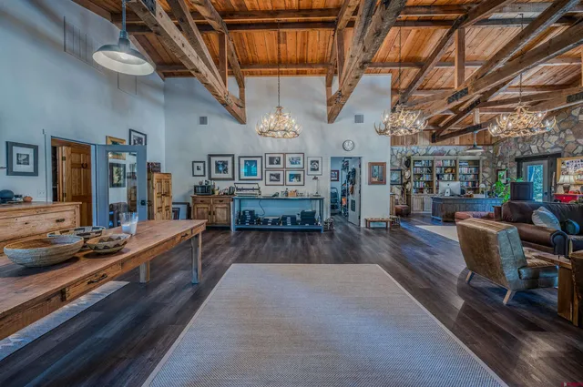 a living room with lots of wooden furniture and a chandelier