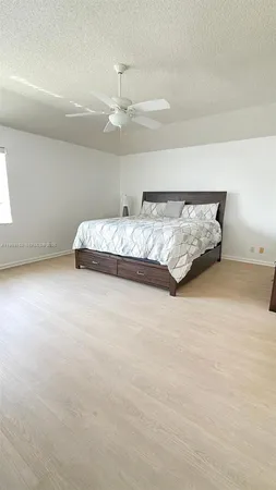 a large bed sitting in a bedroom and a lamp