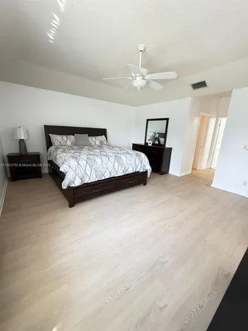 a large bed sitting in a bedroom and a lamp