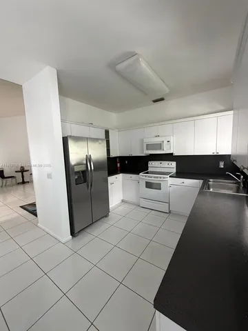 a kitchen with stainless steel appliances a refrigerator sink and stove
