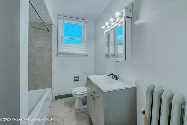 a bath room with a toilet a sink and a bath tub