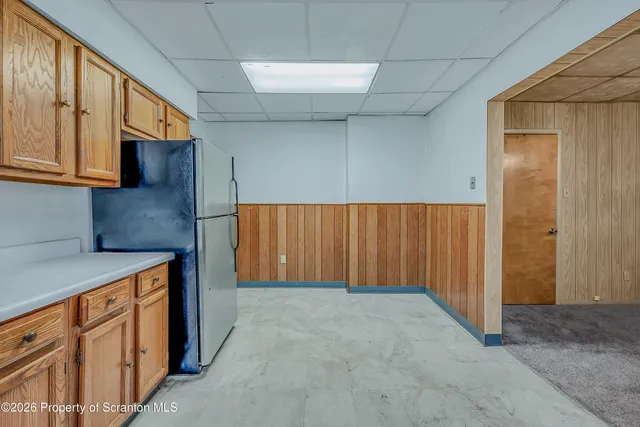 a kitchen with stainless steel appliances granite countertop a refrigerator and wooden cabinets