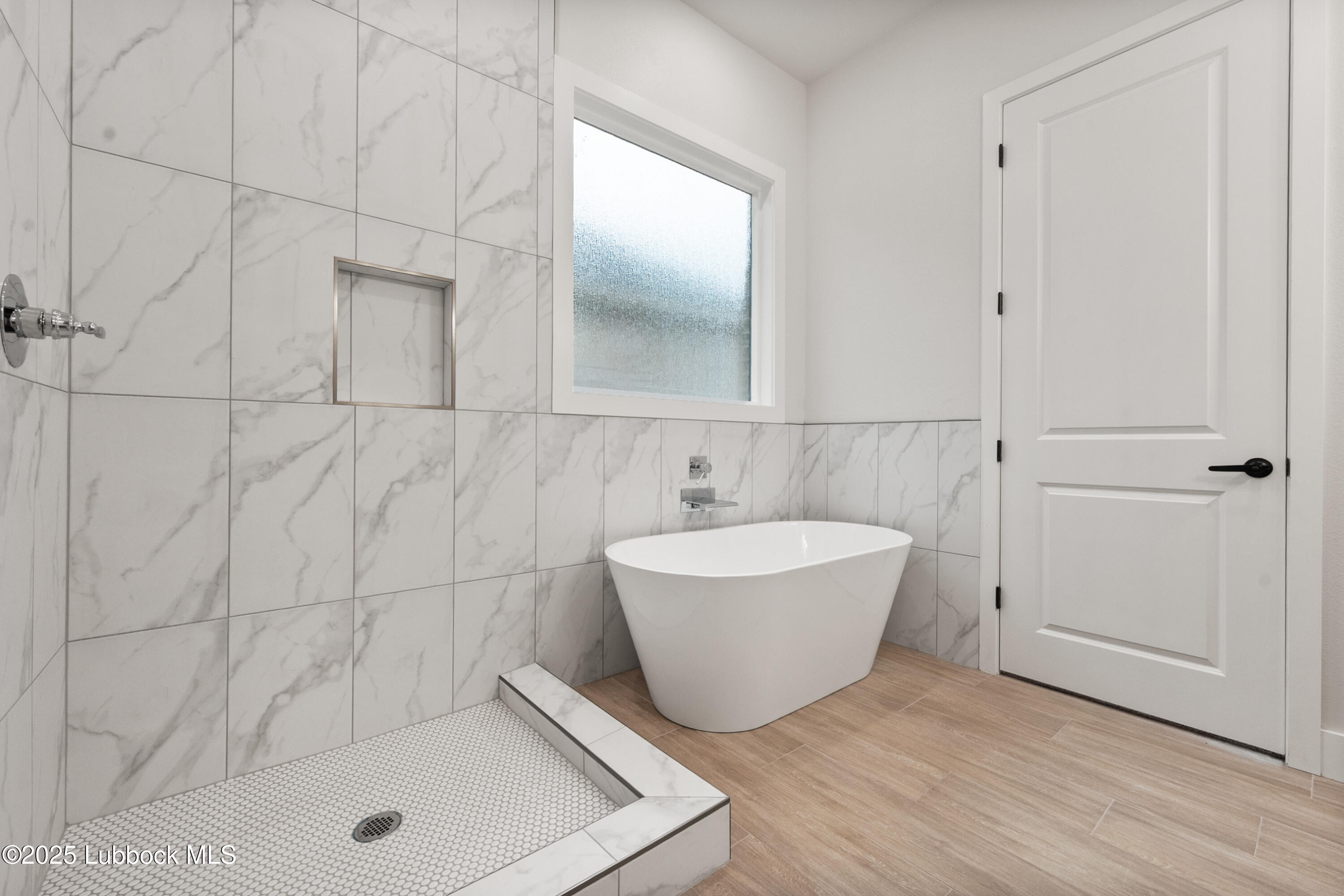 7526 57th Street Lubbock, TX 79407 - Photo 28 of 36 a bathroom with a tub a sink and mirror