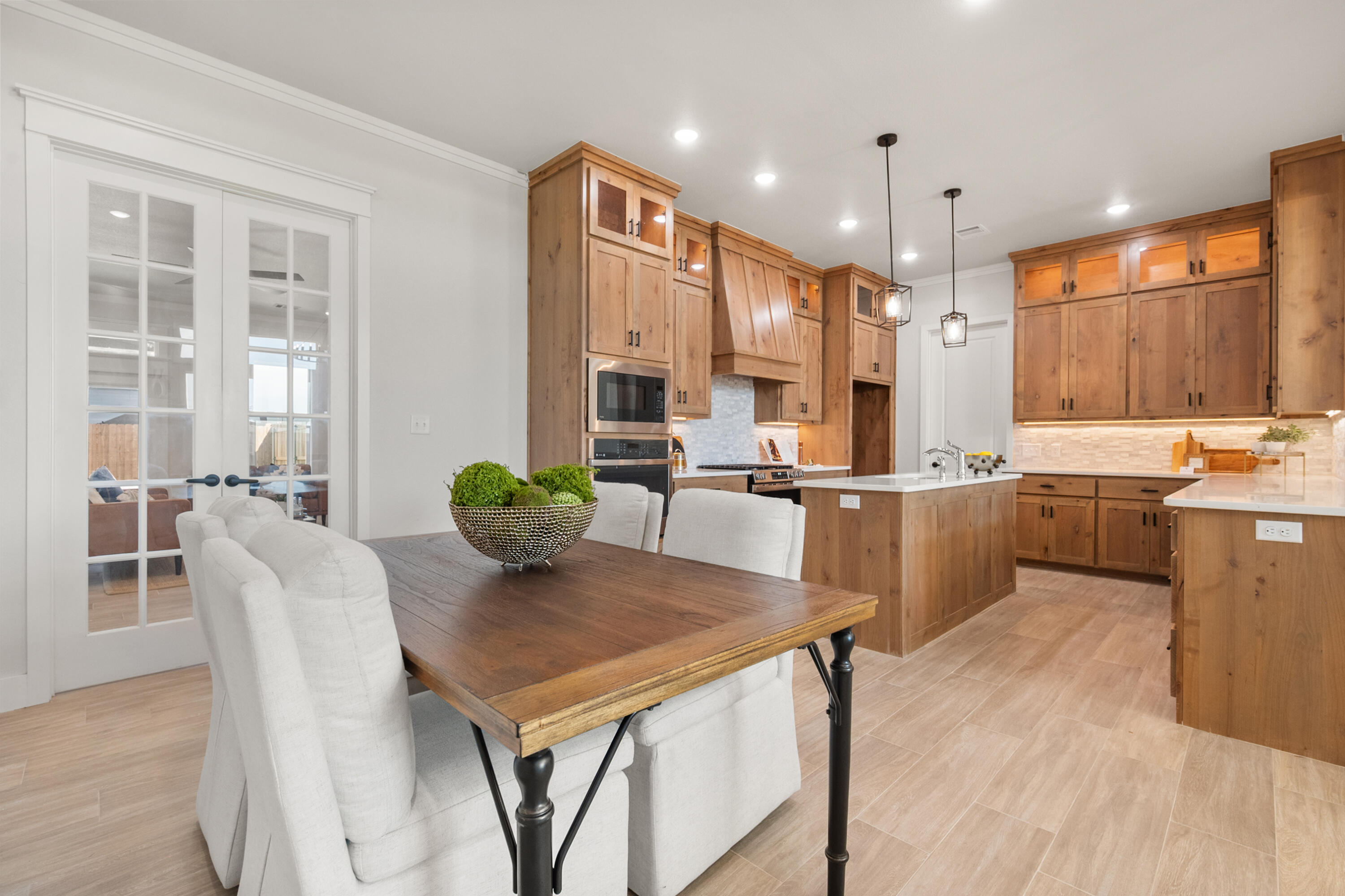 7526 57th Street Lubbock, TX 79407 - Photo 7 of 36 a kitchen with stainless steel appliances kitchen island granite countertop a table chairs and a refrigerator