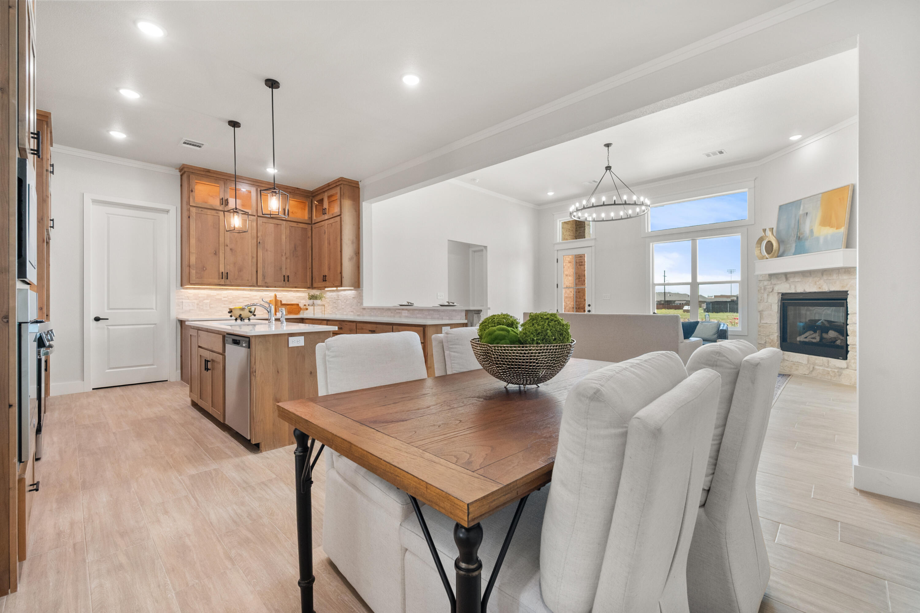 7526 57th Street Lubbock, TX 79407 - Photo 8 of 36 a large kitchen with a table chairs and a refrigerator