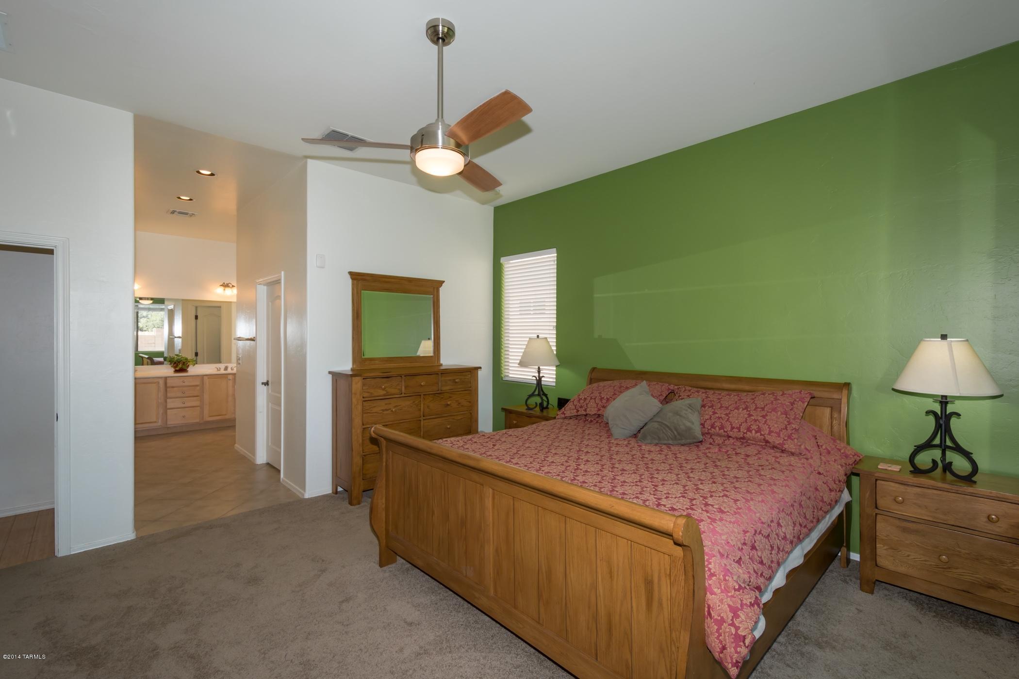 15082 North Holsteiner Road Tucson, AZ 85739 - Photo 24 of 34 a bedroom with a bed and a chandelier