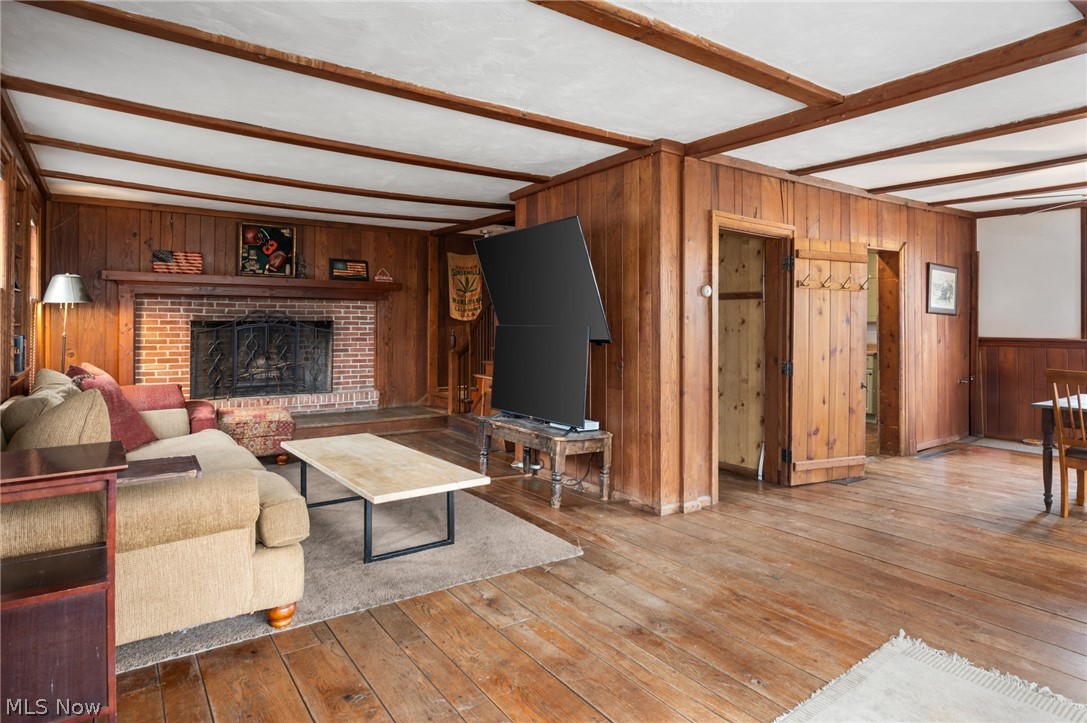 9455 Robinson Road Chardon, OH 44024 - Photo 3 of 33 Living area with beam ceiling, wood walls, hardwood / wood-style floors, and a fireplace