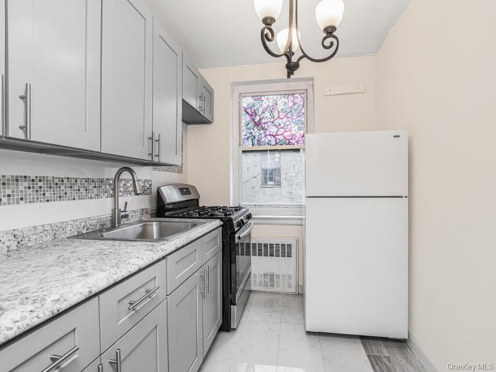 6535 Broadway, Unit 2E Bronx, NY 10471 - Photo 11 of 11 a kitchen with stainless steel appliances granite countertop a sink a stove a refrigerator and cabinets