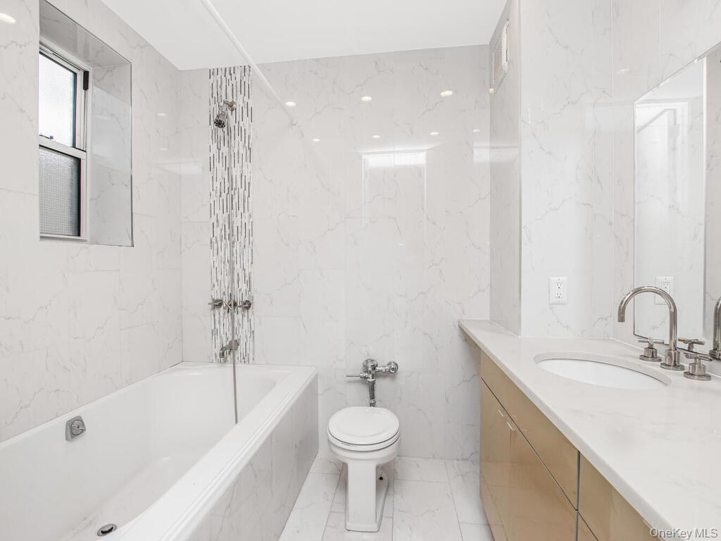 6535 Broadway, Unit 2E Bronx, NY 10471 - Photo 9 of 11 a bathroom with a granite countertop sink toilet and shower