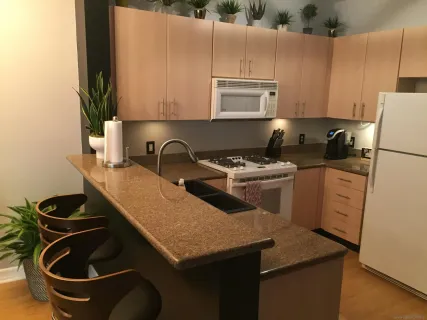 a kitchen with granite countertop a sink a stove and cabinets