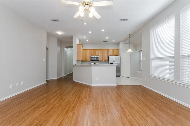 a view of a kitchen with a fridge and wooden floor