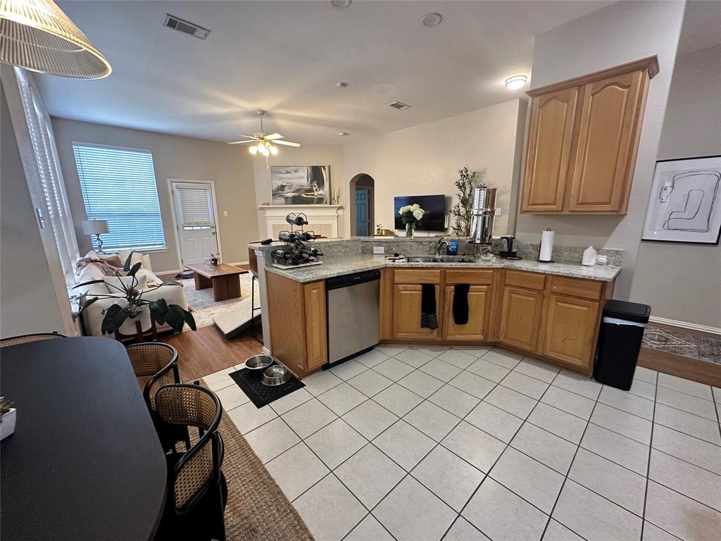 2450 Streamside Court Frisco, TX 75036 - Photo 15 of 28 a kitchen with a sink a stove and chairs