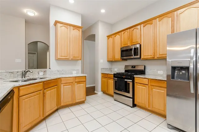 a kitchen with stainless steel appliances granite countertop a stove a sink and a microwave