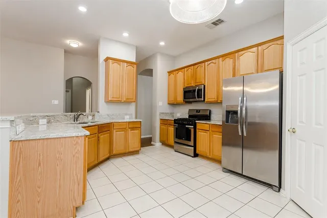 a kitchen with granite countertop a refrigerator and a sink