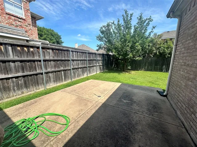 a view of backyard of house with wooden fence