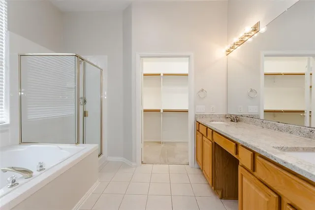 a spacious bathroom with a granite countertop sink a mirror and a bathtub