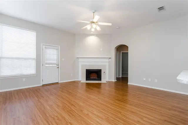 wooden floor fireplace and windows in an empty room