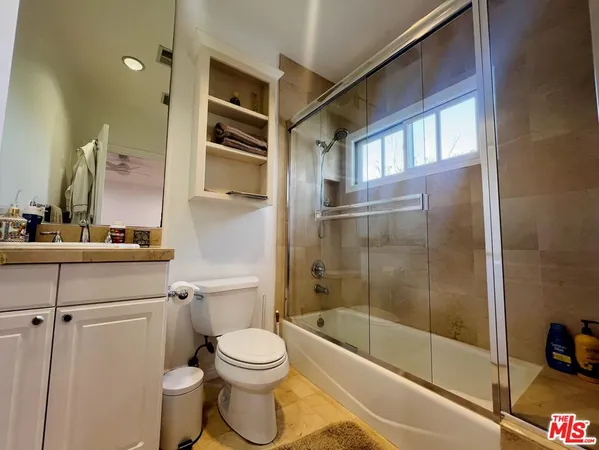 a bathroom with a bathtub shower sink vanity and toilet