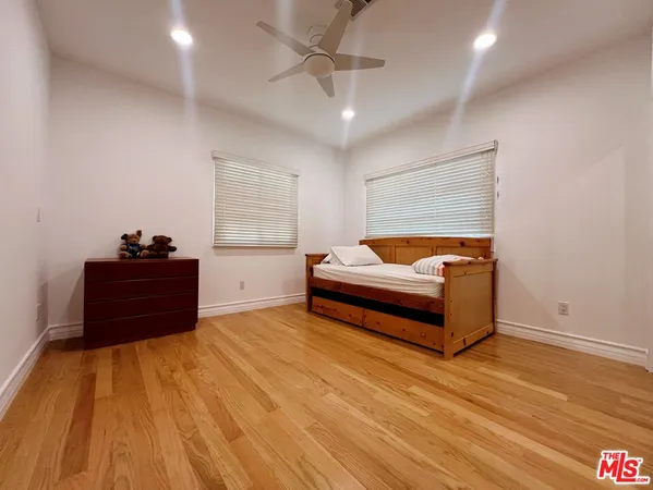 a bedroom with a bed and a ceiling fan