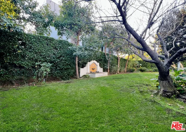 a backyard of a house with a garden and barbeque oven