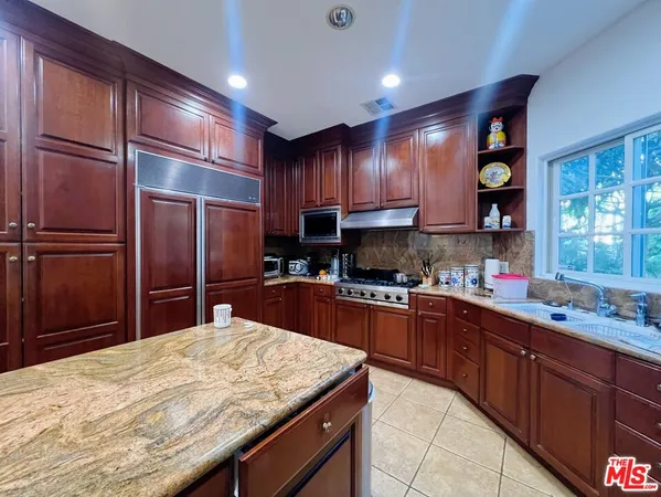 a kitchen with stainless steel appliances granite countertop a refrigerator sink and cabinets