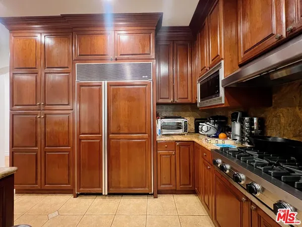 a kitchen with a refrigerator and a stove top oven