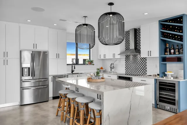 a kitchen with stainless steel appliances granite countertop sink stove refrigerator and cabinets
