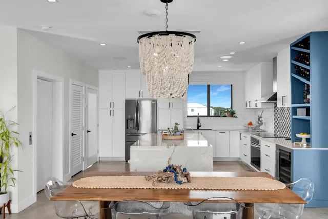 a kitchen with stainless steel appliances kitchen island a dining table and chairs