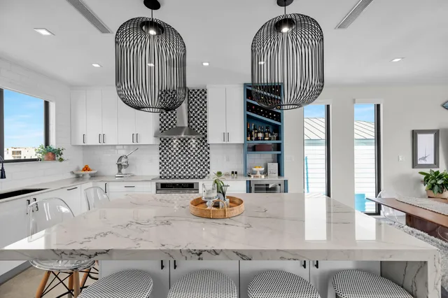 a kitchen with stainless steel appliances granite countertop a dining table chairs and a chandelier
