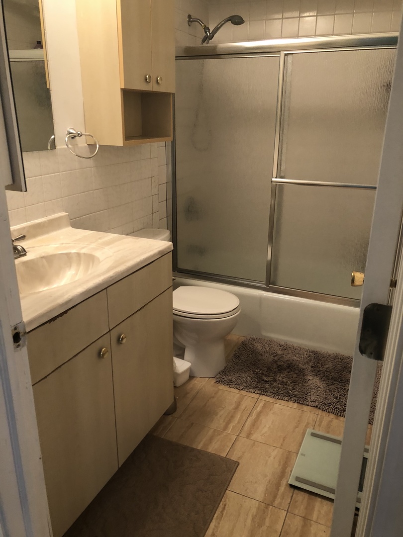 6027 103rd Street, Unit 2D Chicago Ridge, IL 60415 - Photo 8 of 11 a bathroom with a sink a toilet and shower