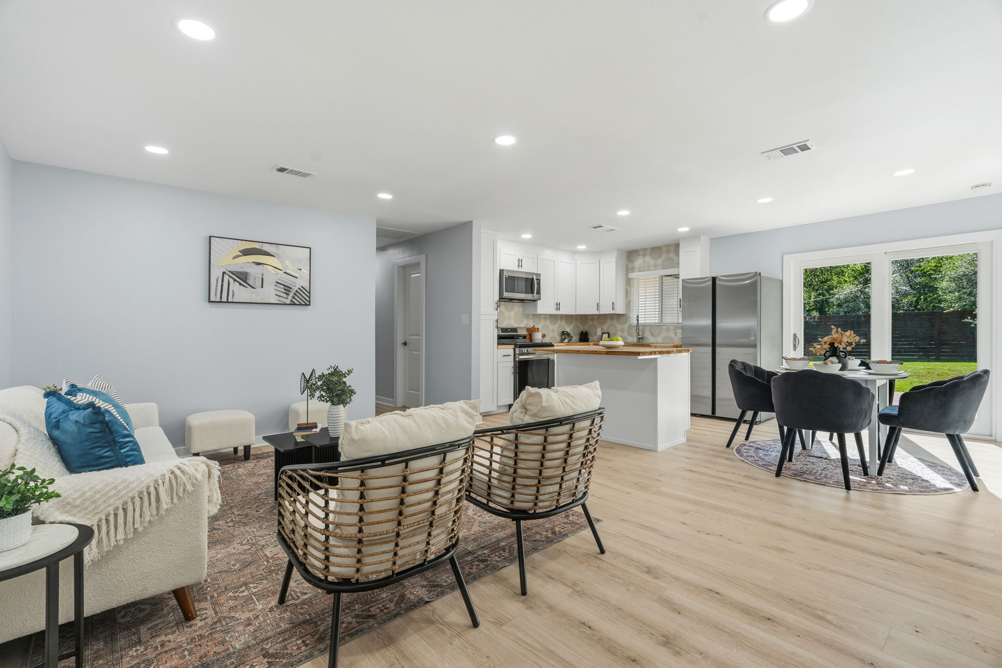 4802 Brighton Road Austin, TX 78745 - Photo 2 of 30 Bright, open-concept living, dining, and kitchen spaces are connected by wide-plank flooring, recessed lighting, and large windows that bring in abundant natural light.
