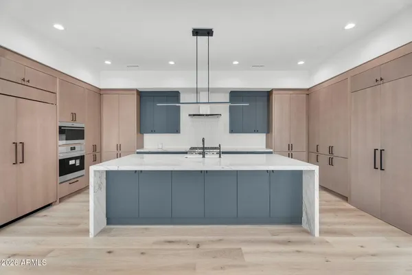 a large kitchen with kitchen island a sink stainless steel appliances and cabinets