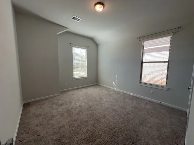 an empty room with windows and closet