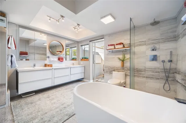 a bathroom with a granite countertop sink a toilet and shower