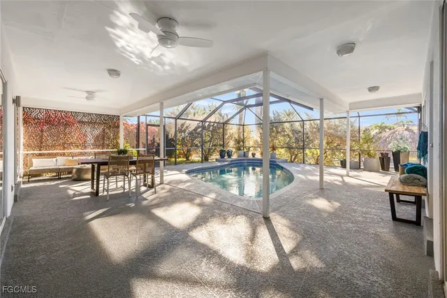 a view of a dining room with furniture a chandelier and kitchen view