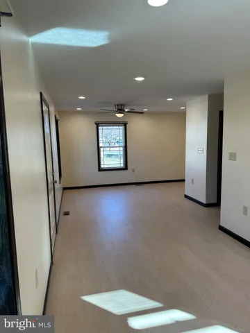 an empty room with windows and refrigerator