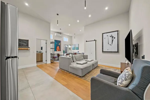 a living room with furniture and a view of kitchen