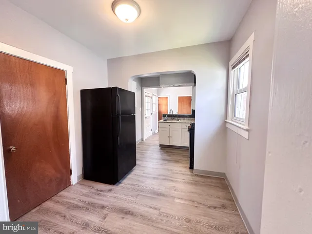 a view of a kitchen with refrigerator and wooden floor