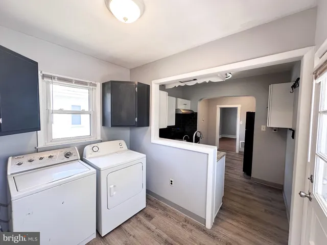 a view of washer and dryer with bathroom in the background