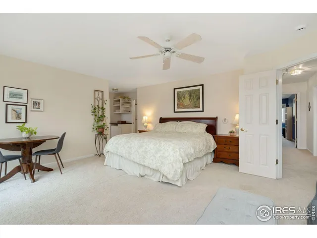 a spacious bedroom with a bed a table and chair