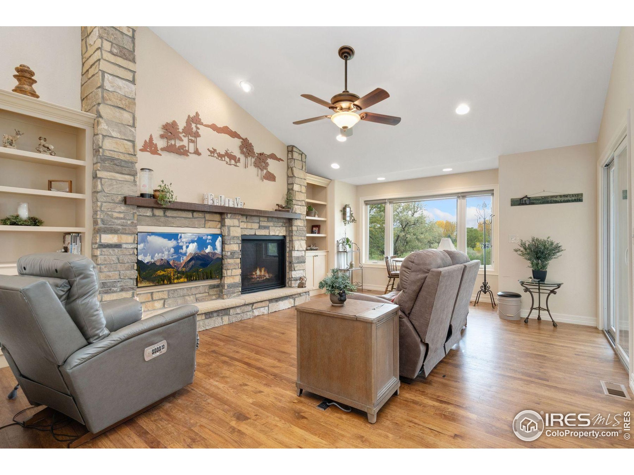 1055 Coho Run Fort Collins, CO 80524 - Photo 35 of 50 a living room with furniture a fireplace and a flat screen tv