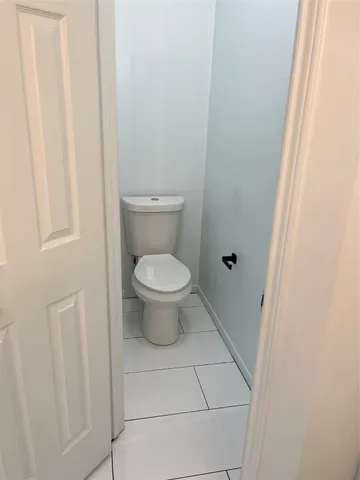 a white toilet sitting next to a shower