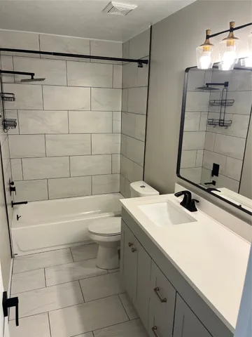 a bathroom with a sink toilet vanity and tub