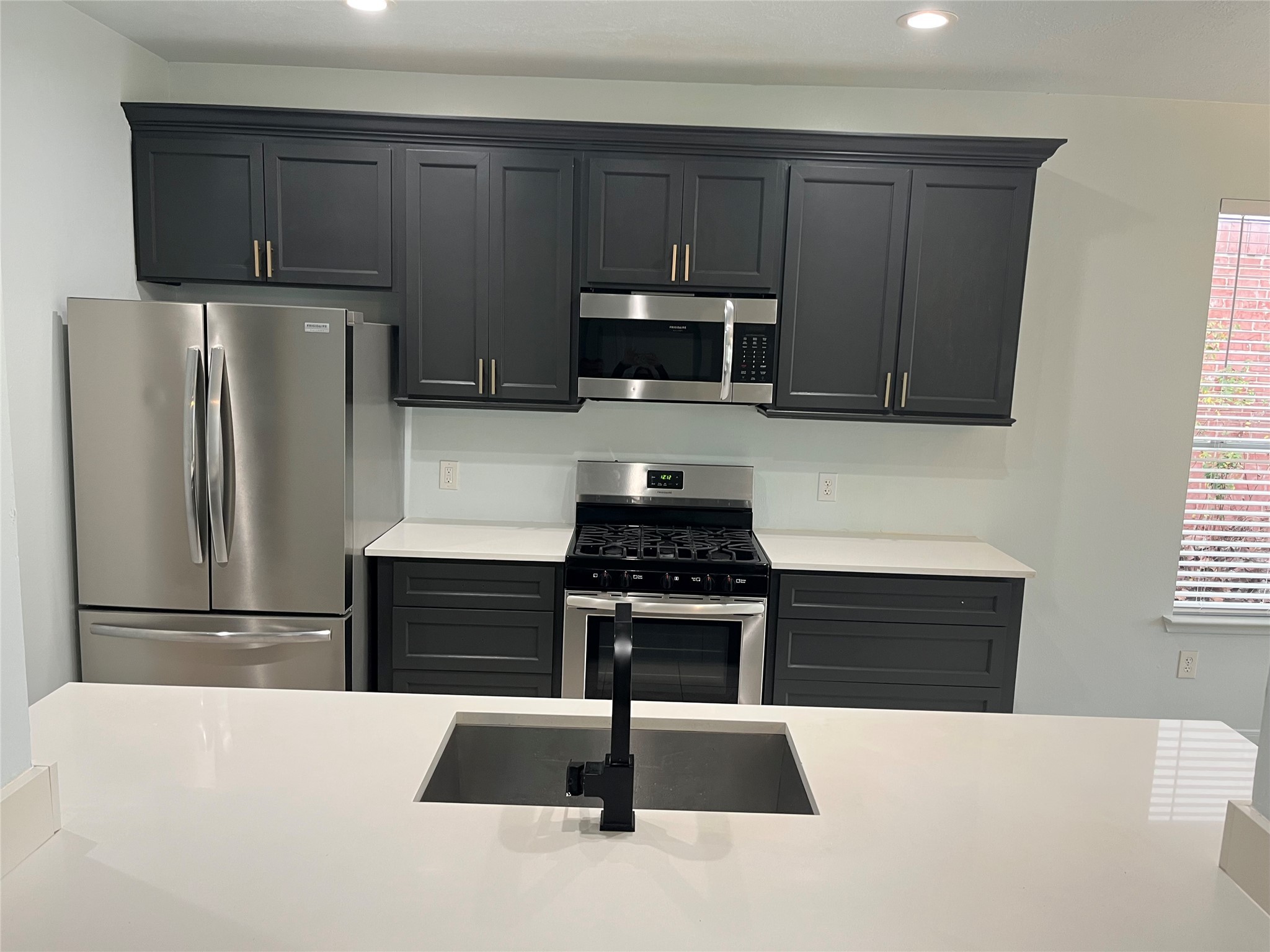 911 Chapwood Court Spring, TX 77373 - Photo 6 of 22 a kitchen with granite countertop a refrigerator stove and microwave