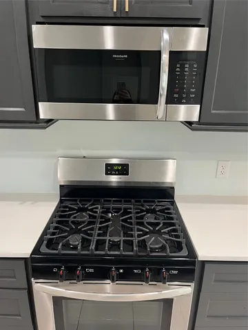 a kitchen with wooden cabinets and a stove top oven